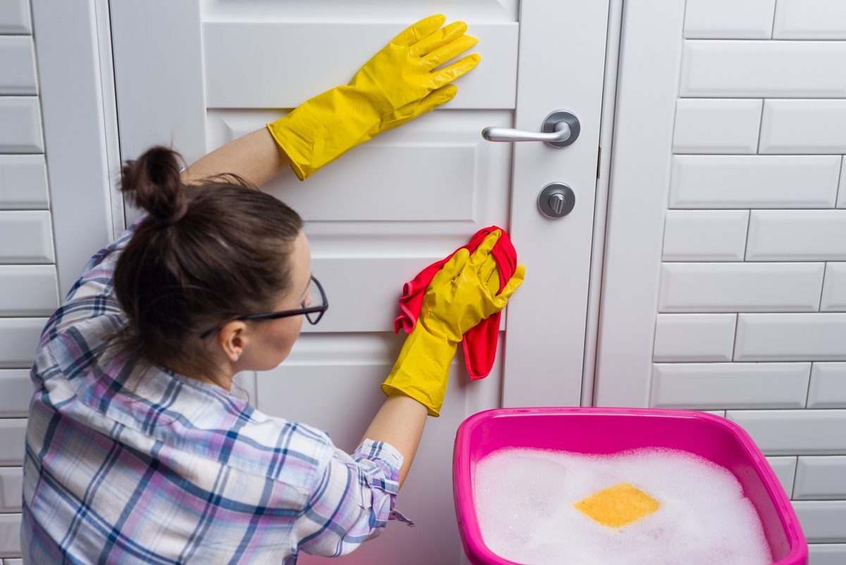 Woman Cleaning House Door